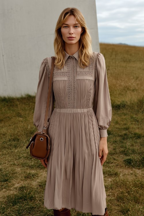 A woman in a soft taupe midi dress with vertical pintuck pleats and a small shoulder bag