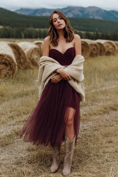 a woman in a deep wine tulle midi dress with a sweetheart neckline and sheer puff sleeves, paired with suede taupe cowboy boots