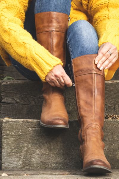 A woman wears sweater with skinny jeans and tight fit round toe cowboy boots