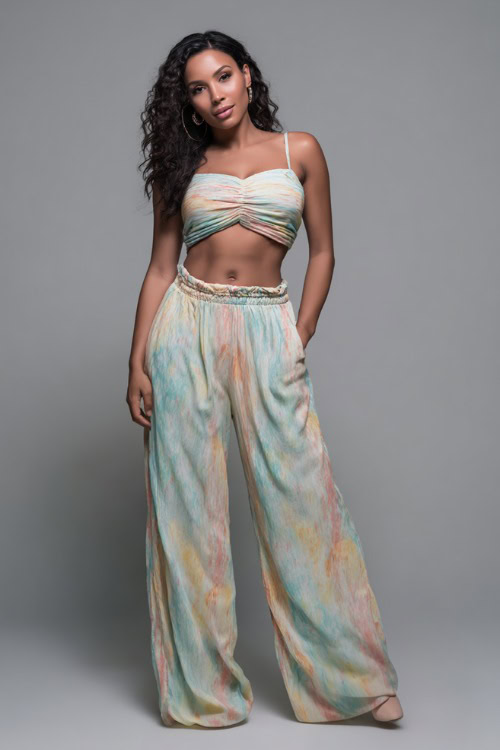 A mid-size woman in a matching two-piece set with a fitted crop top and flowy wide-leg pants, styled for a trendy and breezy summer night out