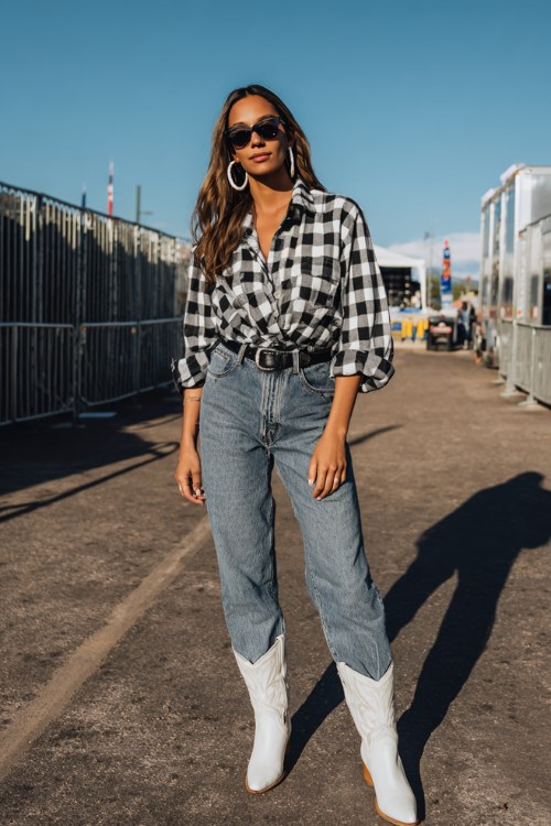 A woman wears faded straight-leg jeans with a black and white check flannel half-tucked, accessorized with white cowboy boots (2)