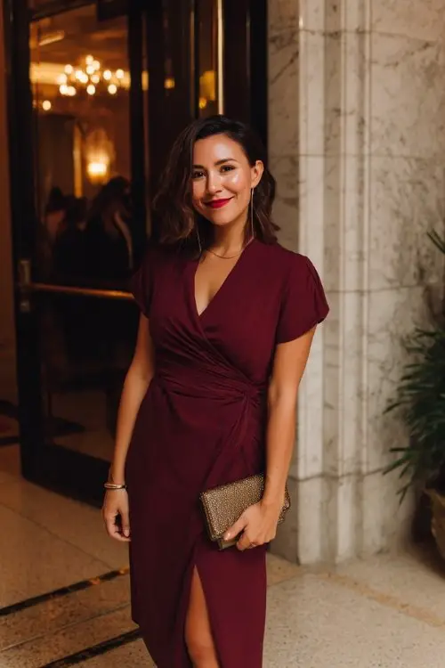 a petite woman in a burgundy wrap midi dress with a slit
