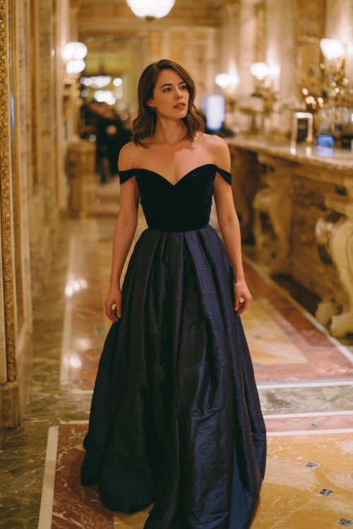 A woman wears a midnight blue ballgown with a fitted velvet bodice, off-the-shoulder neckline, and silk organza skirt (2)