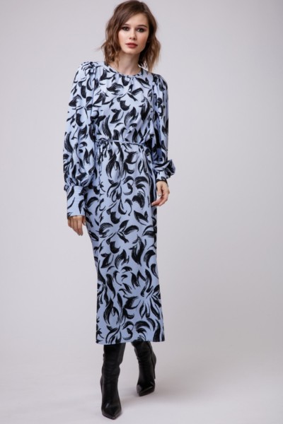 A woman wears long textured dress with black cowboy boots