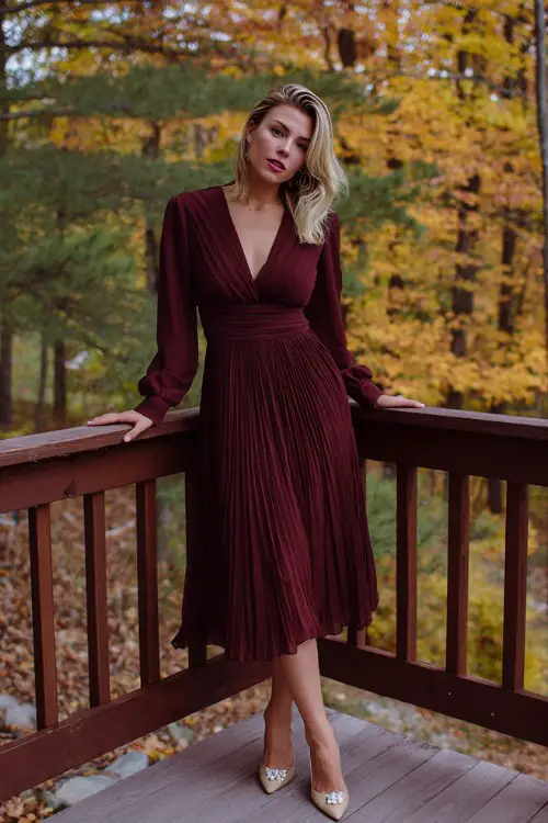 A woman over 30 wears a maroon chiffon pleated dress with cuffed long sleeves, styled with pointed-toe heels and pearl studs (2)