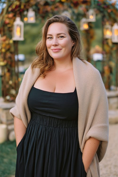 A plus-size woman wears a black square-neck dress with a pleated skirt and a soft beige shawl