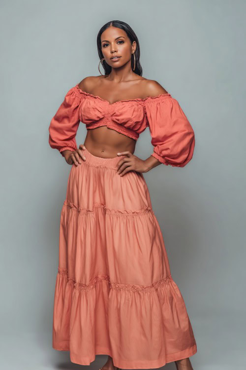 A Black woman wearing a coral crop top with puff sleeves, paired with a flowy tiered maxi skirt and sandals, styled for an elegant summer night look