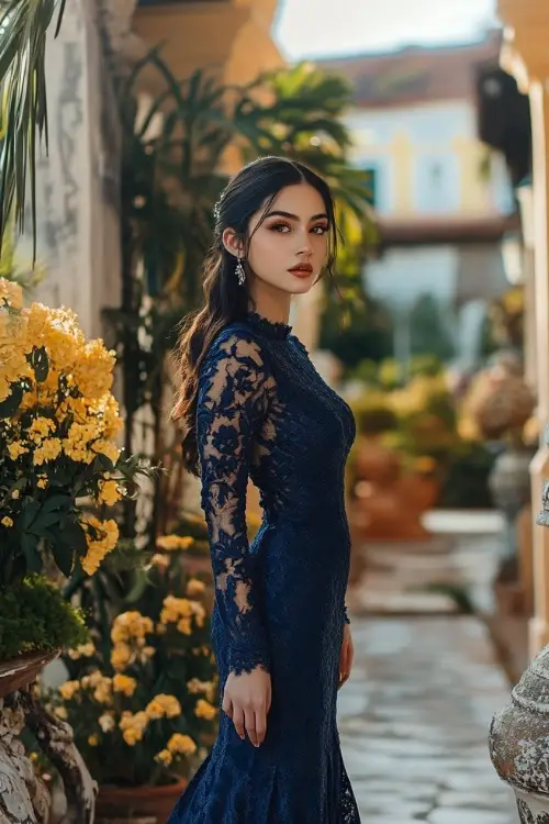 a woman wears a navy blue lace wedding guest dress with long sleeves