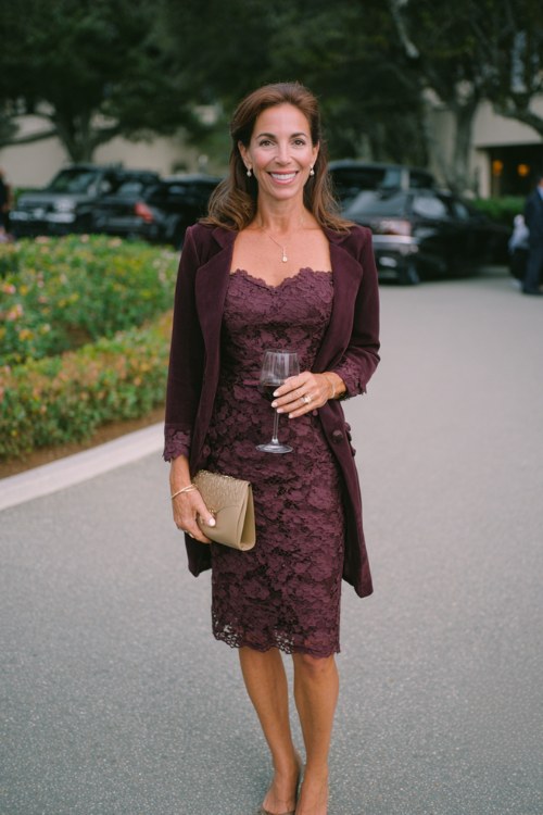 A woman over 30 wears a deep wine lace sheath dress with a matching longline jacket