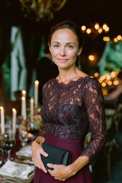 a woman over 50 in a dark plum long-sleeve gown with lace bodice