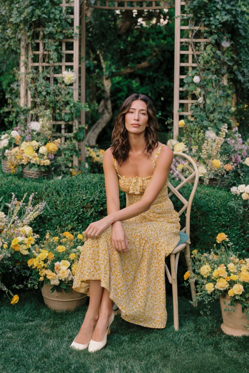 A woman wears a marigold block-print tiered midi with a scalloped square neckline