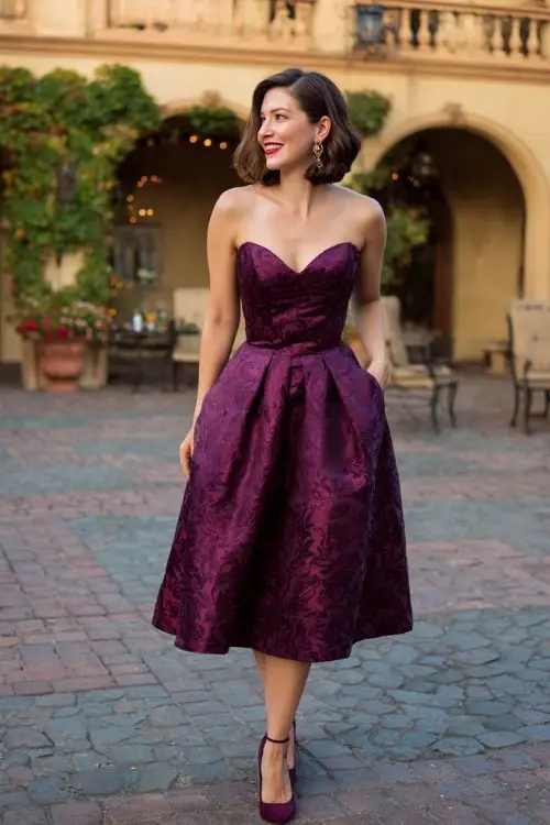 a woman over 50 in a plum brocade fit-and-flare cocktail dress with sweetheart neckline