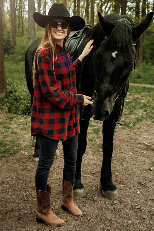 a woman wears cowboy boots with skinny jeans and a plaid shirt