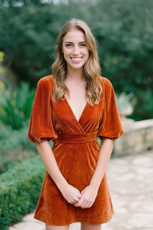 a woman wears a rust short dress for fall wedding