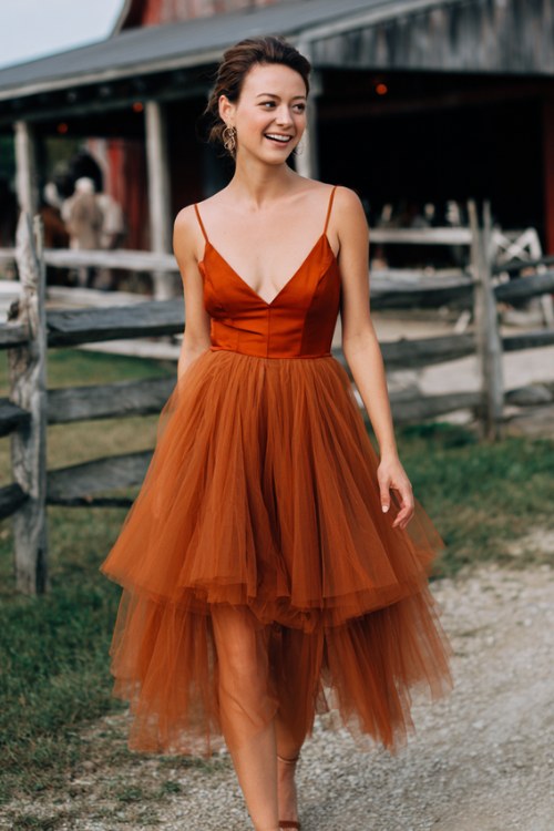 A woman wears a layered tulle skirt dress in burnt orange with a fitted satin bodice (2)