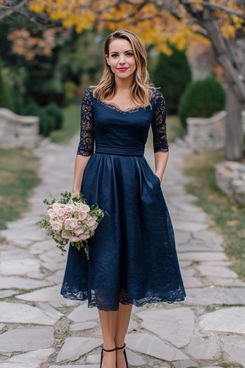 a woman wears a navy wedding guest dress with lace details for fall wedding