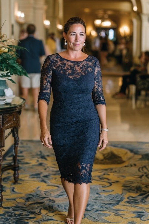 A woman over 40 wears a navy lace sheath dress with three-quarter sleeves and pearl earrings (2)