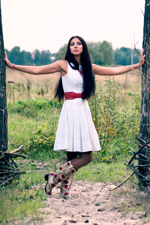 A woman wears white dress with cowboy boots