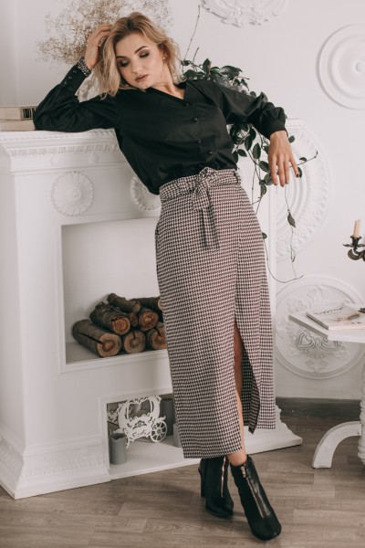 A woman wears split skirt with ankle boots and black top