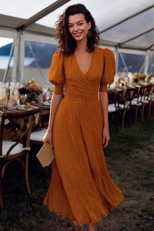 A woman wears a copper polka-dot crepe tea-length dress with soft puff sleeves and a tie waist, styled with slingback pumps and a woven clutch