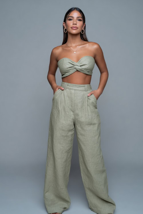 A woman in a matching linen two-piece set with a crop top and wide-leg pants, accessorized with hoop earrings and sandals, ideal for a relaxed summer night look