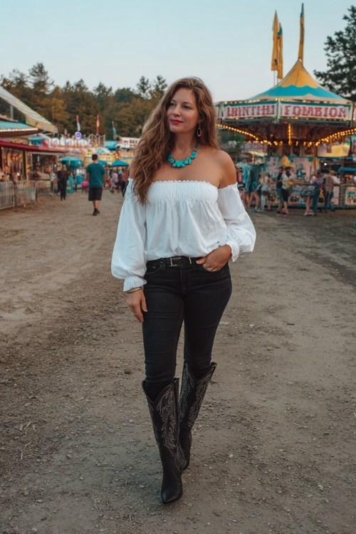 A curvy woman wears skinny jeans with black tall cowboy boots, a white off-shoulder blouse, and turquoise jewelry