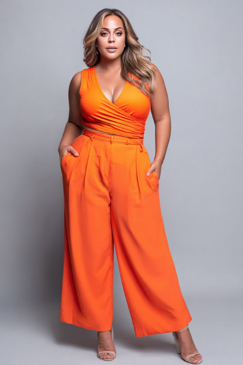 A plus-size woman wearing a bright orange wrap top with high-waisted wide-leg trousers and open-toe heels, styled for a bold and flattering summer night look