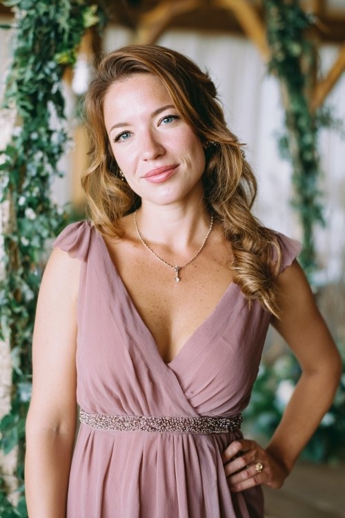 a woman over 50 in a dusty rose chiffon cocktail dress with beaded waistline