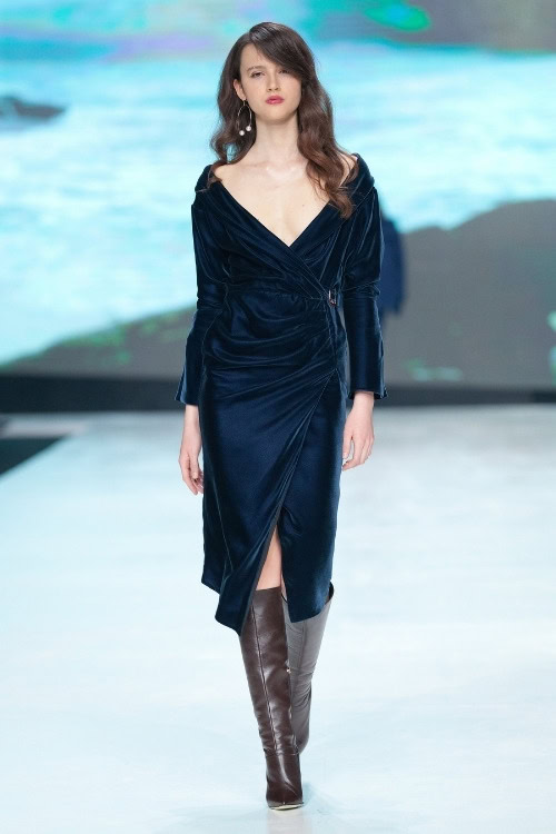 a woman wears brown cowboy boots with a black wrap dress