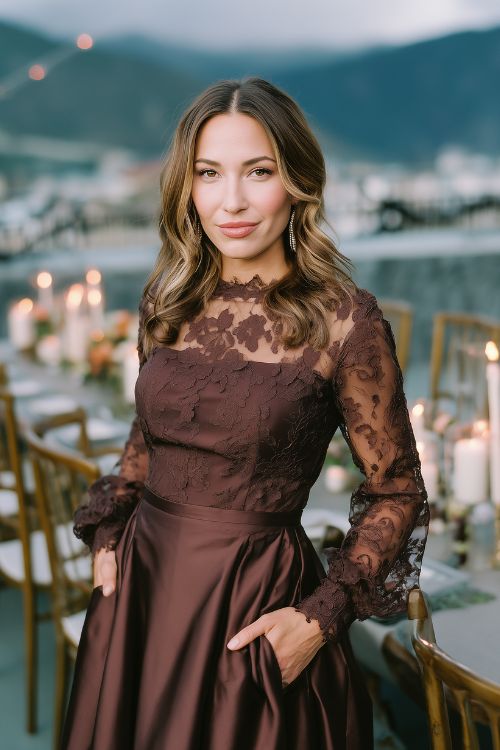 A woman wears a chocolate brown A-line dress with lace sleeves and a defined waistline