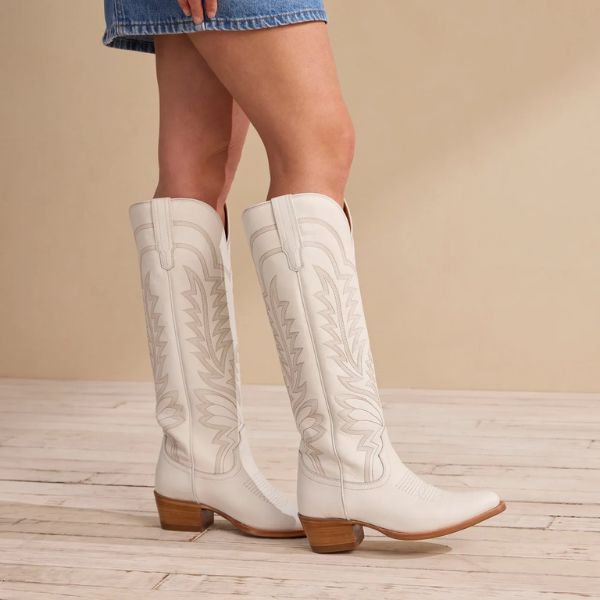 A girl wears The Abby cowboy boots in the room