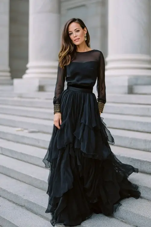 a woman over 50 in a navy chiffon gown with a layered tiered skirt, beaded cuffs, and illusion bateau neckline