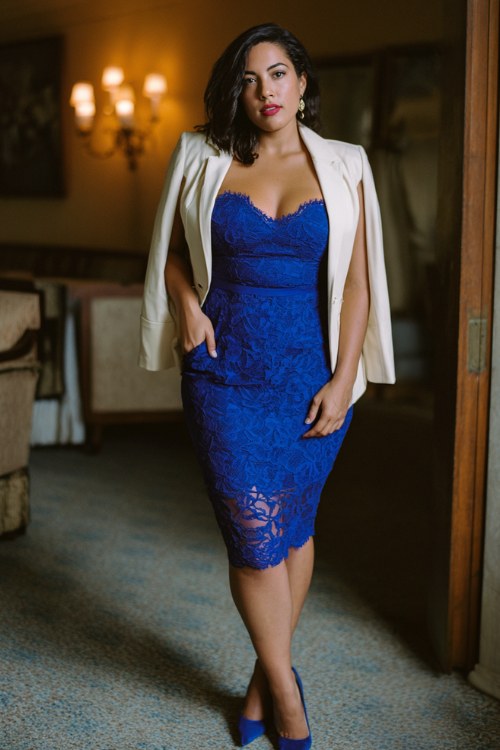 A curvy woman wears a royal blue cocktail dress with lace detailing