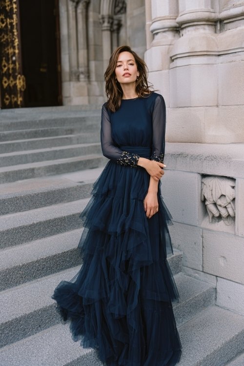 a woman over 50 in a navy chiffon gown with a layered tiered skirt, beaded cuffs, and illusion bateau neckline