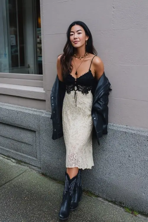 a woman wears a black cowboy boots outfit with a two colored lace dress for date night