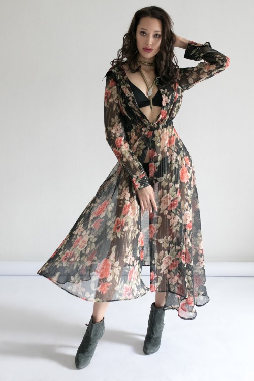 A woman wears cowboy boots with long floral dress