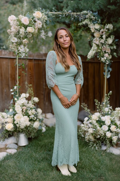A woman over 30 in a sage green lace maxi dress with illusion sleeves and a soft mermaid flare, styled with cream cowboy boots