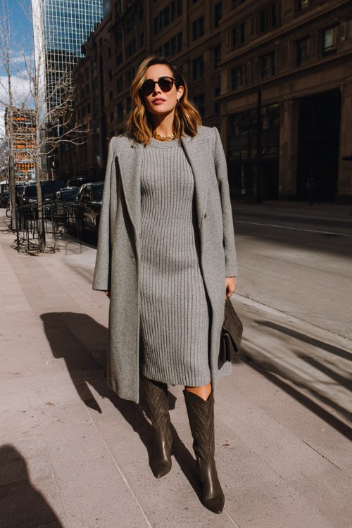 A woman over 30 wears a ribbed knit dress with pointed-toe tall cowboy boots and a longline wool coat