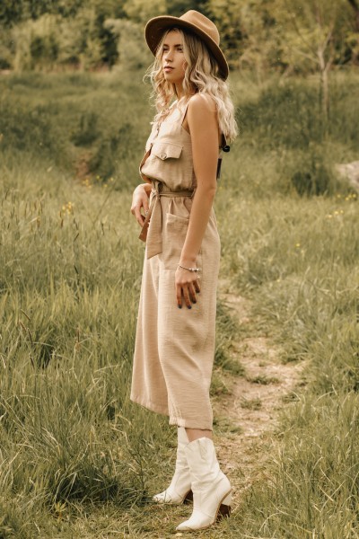 A woman wears white cowboy boots with beige outfit