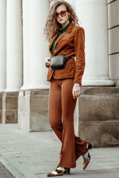 A woman wears animal print cowboy boots with a suits