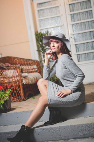 A woman wears grey dress with black cowboy boots