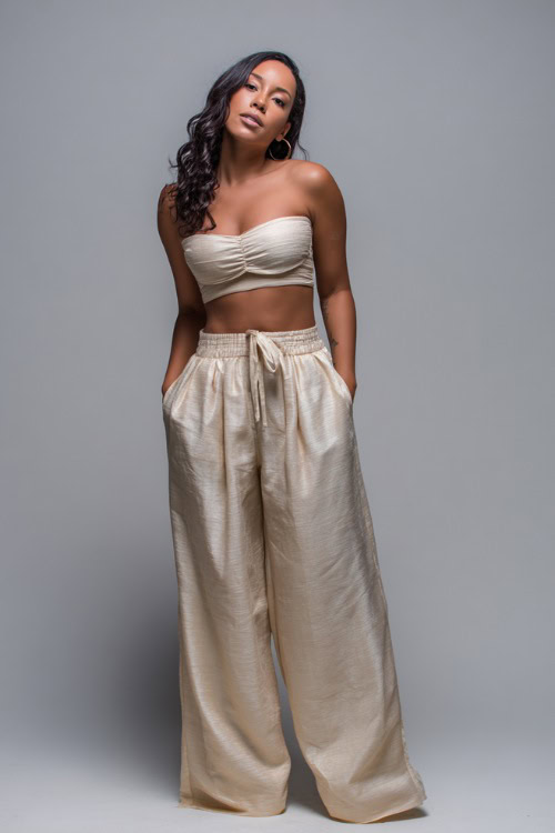 A mid-size woman in a matching two-piece set with a fitted crop top and flowy wide-leg pants, styled for a trendy and breezy summer night out