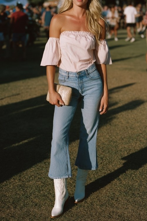 a woman wears an off shoulder blush pink top with crop flare jeans and cowboy boots outfit