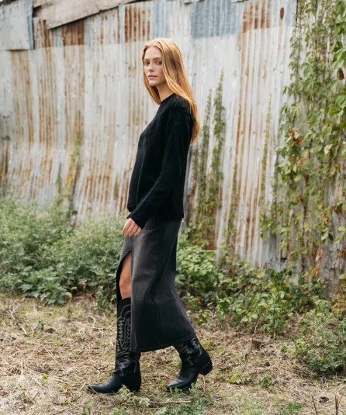 A woman wears split skirt, sweater with The Abby cowboy boots 2