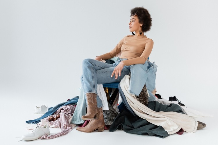 A woman wears wide leg jeans with cowboy boots and tigh t shirt