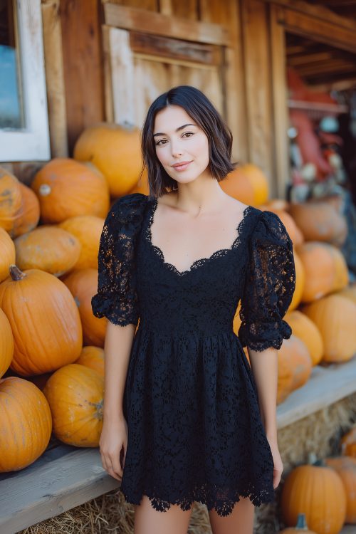 A petite woman in a short black lace dress with scalloped hem and puff sleeves