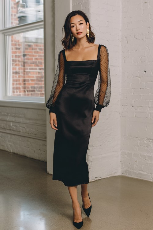 A woman over 50 wears a sleek satin slip dress with long sheer mesh sleeves and a square neckline